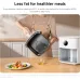 Kitchen view of Xiaomi Air Fryer 6.5L with person pouring oil from basket beside cooked meal on wooden counter.