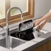 Sink view of Xiaomi Air Fryer Essential 6L basket being rinsed under running water for easy cleaning.