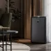 Lifestyle room view of Sharp KI-N50E-H Air Purifier showing powered-on blue light in a cozy living space.