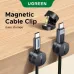 Two UGREEN LP886 magnetic cable clips attached to a wooden surface, holding USB-C cables. An open clip is shown above.