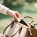 Usage view of Hoco E101A Dual Mode Anti-Lost GPS Tracker being placed inside a handbag for tracking purposes