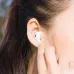 Close-up of a person putting a white BWOO BW50 earbud into their ear, highlighting the comfortable fit.