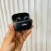Handheld view of Unikyy MAX 60 ANC earbuds showing open charging case with earbuds inside held against textured wall background