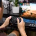 In-use view of the Rapoo V610M Multi-Mode Vibration Gamepad during gameplay, demonstrating immersive control and vibration feedback.