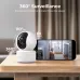 Tabletop view of IMILAB C21 WiFi Camera beside smartphone showing live feed and 360° pan, tilt, and zoom features.