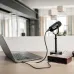Black Shure MV7X broadcast microphone connected to a laptop and audio interface on a wooden desk.