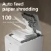 A stack of 100 sheets of paper is being placed into the auto-feed tray of a white Deli paper shredder.