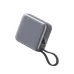 A sleek, square-shaped gray power bank with a digital battery percentage display, a USB port, a power button, and an attached black braided wrist strap.
