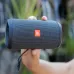 Person holding a JBL Flip Essential 2 portable Bluetooth speaker outdoors, demonstrating its portability.