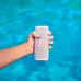Small image of a hand holding a white JBL Flip 5 portable Bluetooth speaker over blue water.