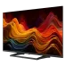 Front angled view of Haier H32S80GFX 32 QLED FHD Android Google TV displaying vibrant abstract waves on slim bezel screen with stand base