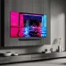 A wall-mounted Samsung 83S90D TV and soundbar display a neon-lit wakeboarder against a dark background.