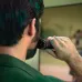 Lifestyle view of Philips MG7940/15 Trimmer used on jawline with circular dial showing adjustable trimming length settings.