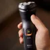 Close-up of Philips X3021/00 Shaver held in hand, showing green power button light and sleek rotary blade design.