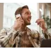 Lifestyle view of the Boya Notra AI Voice Recorder being held during an indoor speaking scenario near a smartphone interface.